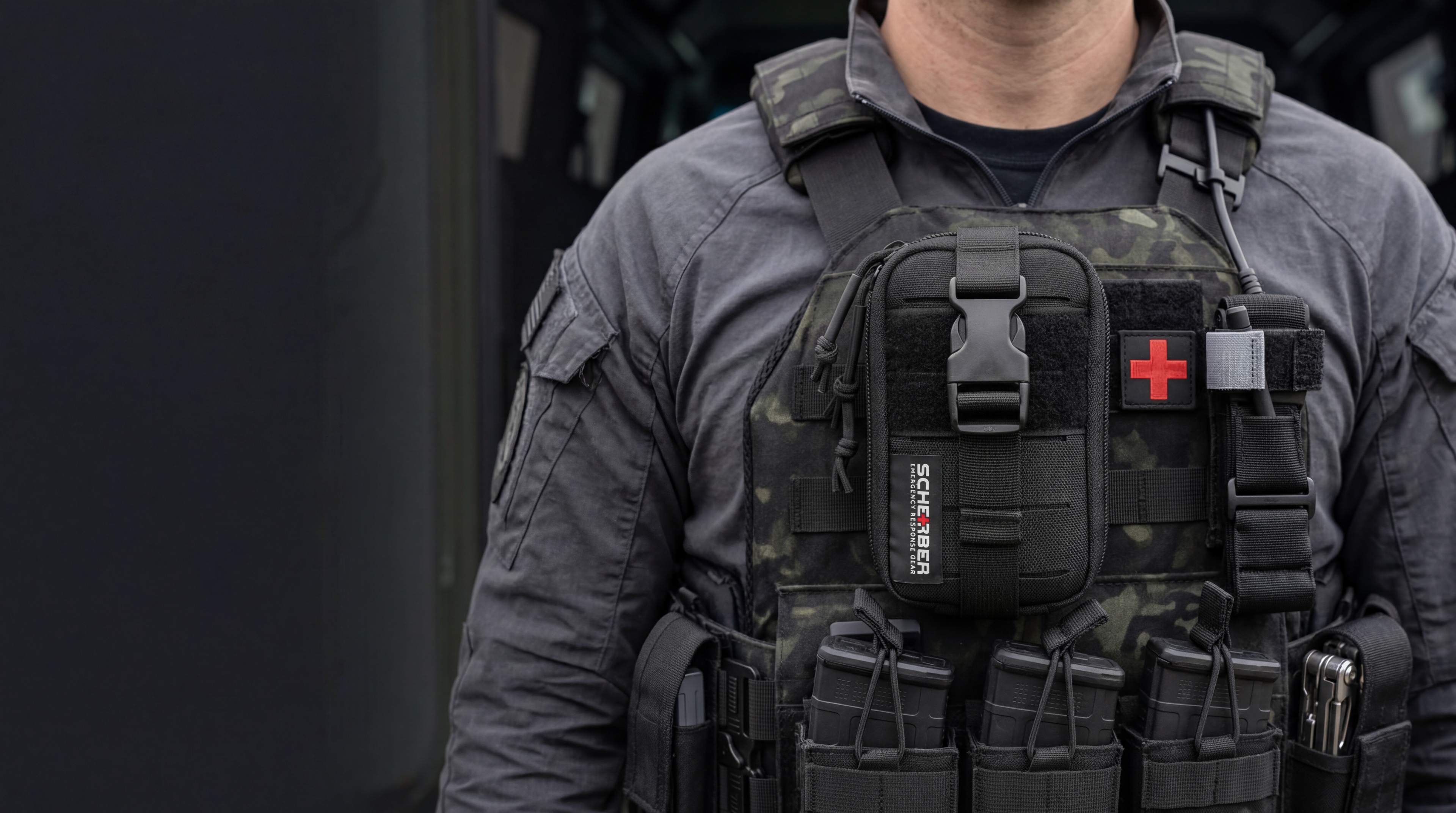 Person wearing a tactical vest with visible branding on a dark background